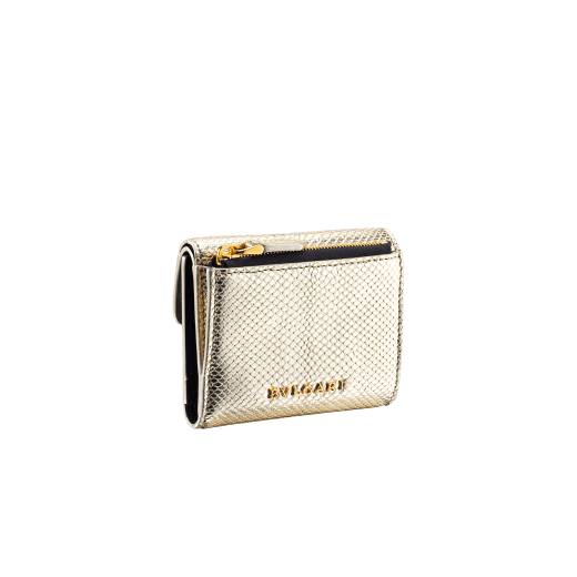 Slender, compact "Serpenti Forever" wallet in "Molten" gold karung skin and black calfskin, offering a touch of radiance for the Winter Holidays. New Serpenti head closure in gold-plated brass, complete with ruby-red enamel eyes. SEA-SLIMCOMPACT-MoltK image 4