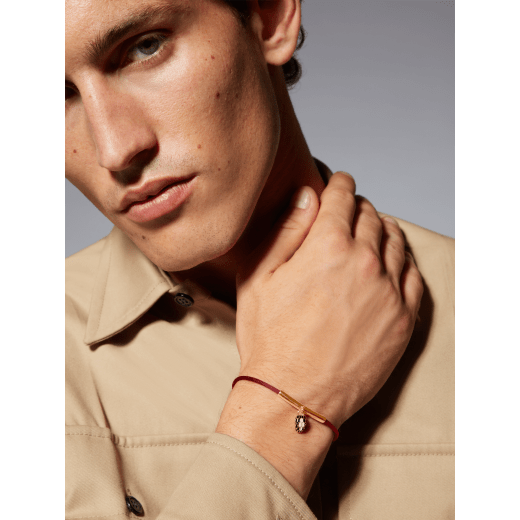"Serpenti Forever" bracelet in ruby red fabric with a gold-plated brass plate. Iconic snakehead charm enamelled in black and white agate, with seductive black enamel eyes. SERP-MINISTRINGc image 3