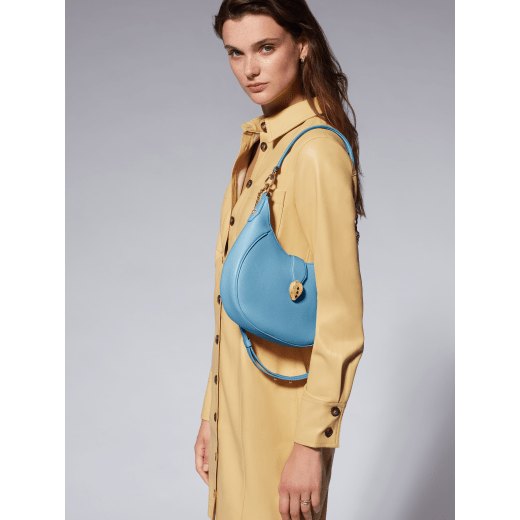 Serpenti Ellipse medium shoulder bag in Urban grain and smooth Niagara sapphire blue calf leather with cloud topaz blue gros grain lining. Captivating snakehead closure in gold-plated brass embellished with black onyx scales and red enamel eyes. 1190-UCL image 7