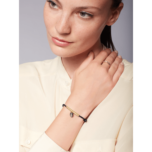 "Serpenti Forever" bracelet in ruby red fabric with a gold-plated brass plate. Iconic snakehead charm enamelled in black and white agate, with seductive black enamel eyes. SERP-MINISTRINGc image 2