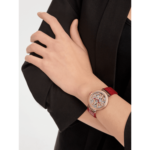 LVCEA Skeleton watch with mechanical manufacture movement, automatic winding and skeleton execution, polished stainless steel case, 18 kt rose gold bezel, openwork BVLGARI logo dial and links, and red alligator bracelet. Water-resistant up to 50 metres. 103373 image 1