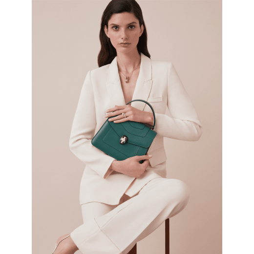 “Serpenti Forever” top handle bag in daisy topaz calf leather. Iconic snake head closure in light gold plated brass enriched with black and white enamel and green malachite eyes. 1050-CL image 4
