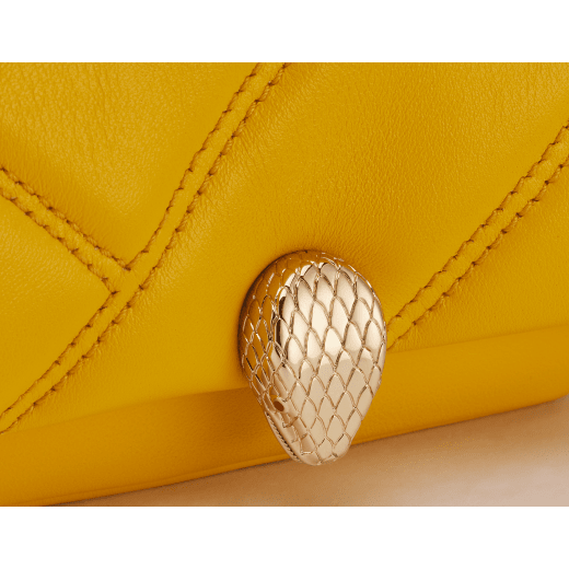 Serpenti Cabochon micro bag in gold calf leather with a maxi matelassé pattern and black nappa leather lining. Captivating snakehead closure in light gold-plated brass embellished with red enamel eyes. SCB-NANOCABOCHONb image 4