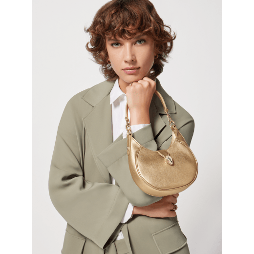 Serpenti Ellipse small crossbody bag in Urban grain and smooth ivory opal calf leather with flamingo quartz pink grosgrain lining. Captivating snakehead closure in gold-plated brass embellished with black onyx scales and red enamel eyes. 1204-UCL image 15