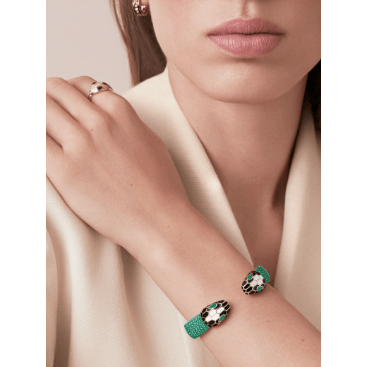 Serpenti Forever bangle bracelet in light gold-plated brass with emerald green galuchat skin inserts. Captivating contraire snakehead motif embellished with black and white agate enamel scales and emerald green enamel eyes. SPContr-G-EG image 2