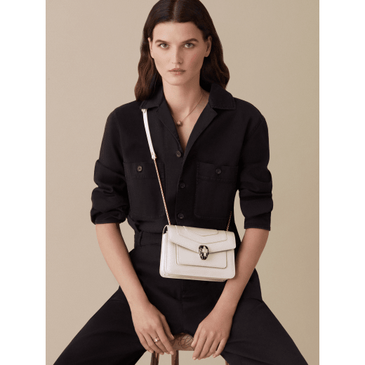 “Serpenti Forever” crossbody bag in white agate calf leather with a varnished and pearled effect. Iconic snakehead closure in light gold plated brass enriched with black and pearled white agate enamel and black onyx eyes. 1082-VCL image 4