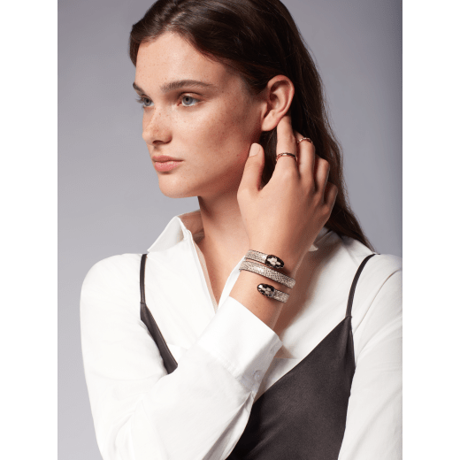 Serpenti Forever Cleopatra multi-coiled bangle bracelet in milky opal beige metallic karung skin. Double snakehead décor in light gold-plated brass embellished with black and glitter milky opal beige enamel scales, and black enamel eyes. Cleopatra-MK-MO image 2
