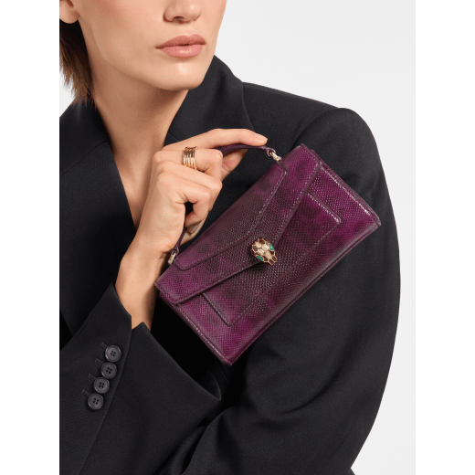 Serpenti Forever phone case in Smeraldo Prezioso shiny karung with black nappa leather lining. Captivating snakehead magnetic closure in gold-plated brass embellished with gold-plated and black enamel scales, and black onyx eyes. SEA-PHONEPOUCH-Kar image 1