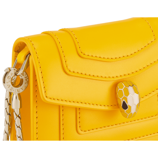 Serpenti Forever miniature bag charm in sun citrine yellow calf leather with Sahara amber light brown calf leather interior. Captivating snakehead press button closure in light gold-plated brass, embellished with sun citrine yellow and white agate enamel scales, and black enamel eyes. SERP-BAG-CHARM-CLa image 4