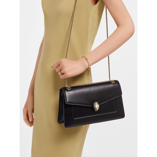 Serpenti Forever medium shoulder bag in black calf leather with black nappa leather lining. Captivating snakehead magnetic closure in light gold-plated brass embellished with beige noisette enamel and light gold-plated brass scales, and black onyx eyes. SEA-001-1344M image 2
