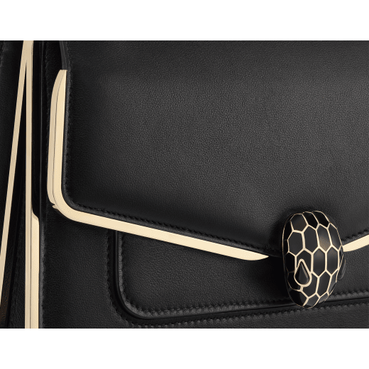 Serpenti Forever medium shoulder bag in black Metropolitan calf leather with light gold-plated brass frames and black nappa leather lining. Captivating snakehead magnetic closure in light gold-plated brass embellished with black enamel scales, and black onyx eyes. 1077-MF image 5