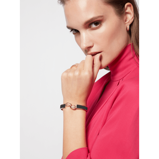 Serpenti Forever bangle in gold-plated brass with black Metropolitan calf leather inserts. Captivating double snakehead hinge closure in gold-plated brass embellished with red enamel eyes. SERP-HINGEBRCLT-MCL-B image 2