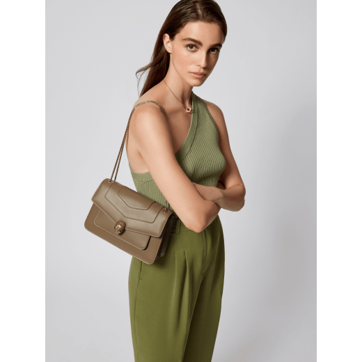 Serpenti Forever medium shoulder bag in black calf leather with emerald green grosgrain lining. Captivating snakehead closure in light gold-plated brass embellished with black and white agate enamel scales and green malachite eyes. 1077-CLa image 1