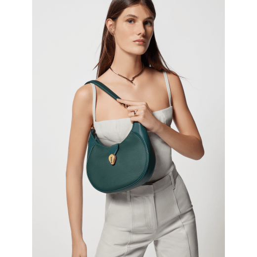 Serpenti Ellipse medium shoulder bag in Urban grain and smooth Niagara sapphire blue calf leather with cloud topaz blue grosgrain lining. Captivating snakehead closure in gold-plated brass embellished with black onyx scales and red enamel eyes. 1190-UCL image 9