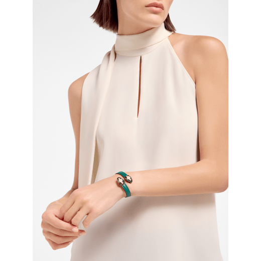 Serpenti Forever soft bangle bracelet in emerald green calf leather. Captivating contraire snakehead décor in light gold-plated brass embellished with black and white agate enamel scales and emerald green enamel eyes. SERP-SOFT-CONTR image 1