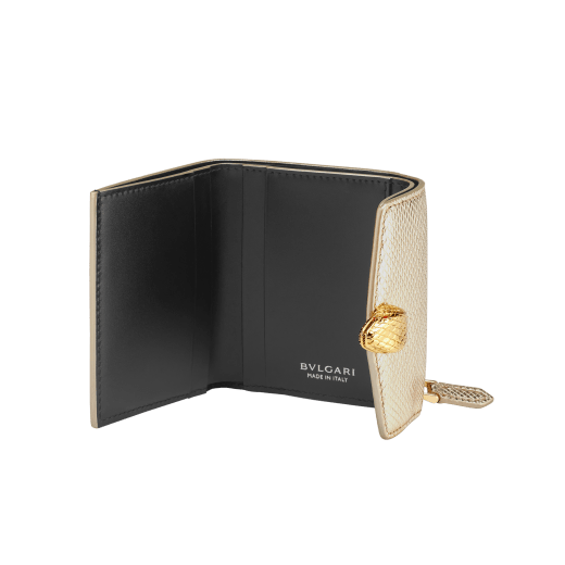 Slender, compact "Serpenti Forever" wallet in "Molten" gold karung skin and black calfskin, offering a touch of radiance for the Winter Holidays. New Serpenti head closure in gold-plated brass, complete with ruby-red enamel eyes. SEA-SLIMCOMPACT-MoltK image 3