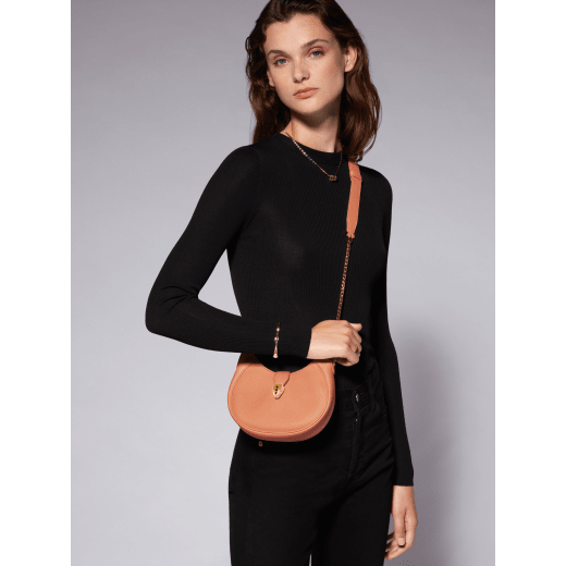 Serpenti Ellipse small crossbody bag in coral carnelian orange Urban grained calf leather with silky coral pink grosgrain lining. Captivating snakehead closure in gold-plated brass embellished with black onyx scales and red enamel eyes. 1204-UCLb image 6
