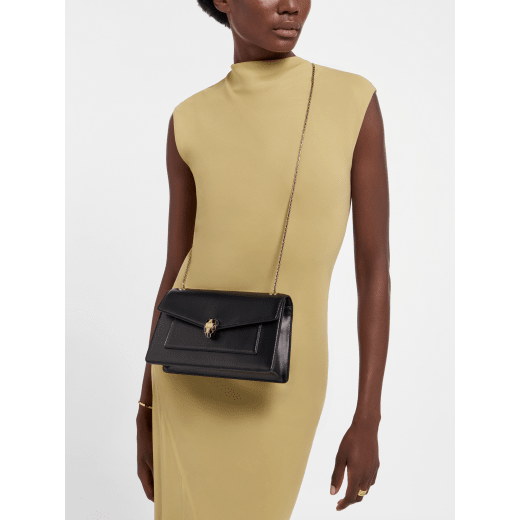 Serpenti Forever medium shoulder bag in black calf leather with black nappa leather lining. Captivating snakehead magnetic closure in light gold-plated brass embellished with beige noisette enamel and light gold-plated brass scales, and black onyx eyes. SEA-001-1344M image 1