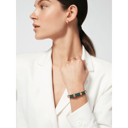 Serpenti Forever bracelet in forest emerald green calf leather. Multiple captivating snakehead rivets in light gold-plated brass embellished with red enamel eyes, and hook-and-eye closure. SER-MULTIHEADS-MCL-FE image 2