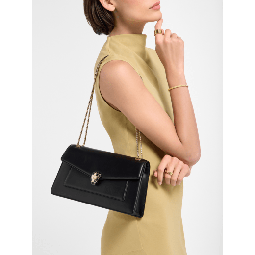Serpenti Forever medium shoulder bag in black calf leather with black nappa leather lining. Captivating snakehead magnetic closure in light gold-plated brass embellished with beige noisette enamel and light gold-plated brass scales, and black onyx eyes. SEA-001-1344M image 1