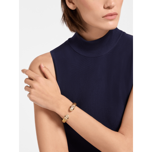 Serpenti Forever bangle bracelet in gold-finished brass with soft gold nappa leather inserts. Captivating contraire snakehead motif in gold-finished brass embellished with pavé-set white zirconia stones and black enamel eyes. BRACLT-SP-CONTR-softnappa image 1