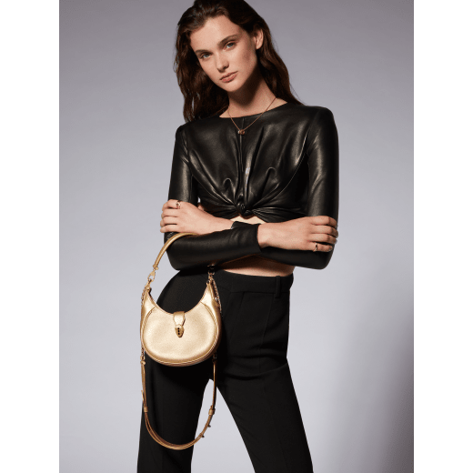 Serpenti Ellipse small crossbody bag in Urban grain and smooth ivory opal calf leather with flamingo quartz pink grosgrain lining. Captivating snakehead closure in gold-plated brass embellished with black onyx scales and red enamel eyes. 1204-UCL image 8