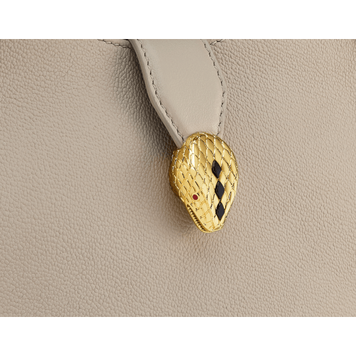 Serpenti Ellipse small crossbody bag in Urban grain and smooth ivory opal calf leather with flamingo quartz pink gros grain lining. Captivating snakehead closure in gold-plated brass embellished with black onyx scales and red enamel eyes. 1204-UCLa image 6
