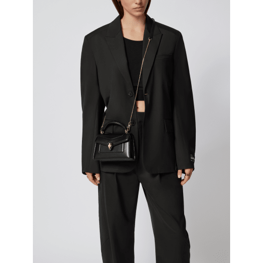 Serpenti Forever mini top handle bag in black calf leather with black nappa leather lining. Captivating snakehead magnetic closure in light gold-plated brass embellished with black enamel and light gold-plated brass scales, and black onyx eyes. SEA-1283-CL image 2