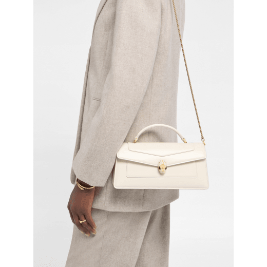 Serpenti Forever Elongated top handle bag in black calf leather with black nappa leather lining. Captivating snakehead magnetic closure in light gold-plated brass embellished with black enamel and light gold-plated brass scales, and black onyx eyes. SEA-001-1390S image 1
