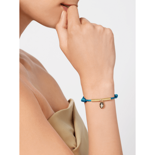 Serpenti Forever bracelet in linden peridot yellowish green fabric. Light gold-plated brass thread and captivating snakehead charm embellished with black and white agate enamel scales and black enamel eyes. SERP-MINISTRINGf image 1