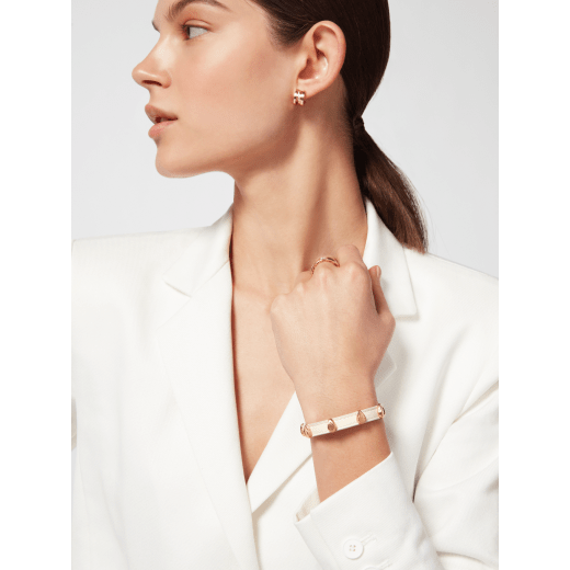 Serpenti Forever bracelet in ivory opal calf leather. Multiple captivating snakehead embellishments in gold-plated brass finished with red enamel eyes, and hook-and-eye closure. SER-MULTIHEADS-MCL-IO image 1