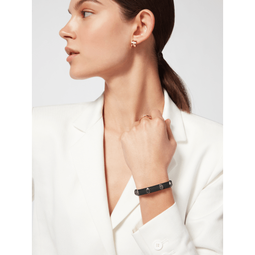 Serpenti Forever bracelet in black calf leather. Multiple captivating snakehead rivets in dark ruthenium-plated brass embellished with red enamel eyes, and hook-and-eye closure. SER-MULTIHEADS-MCL-B image 1