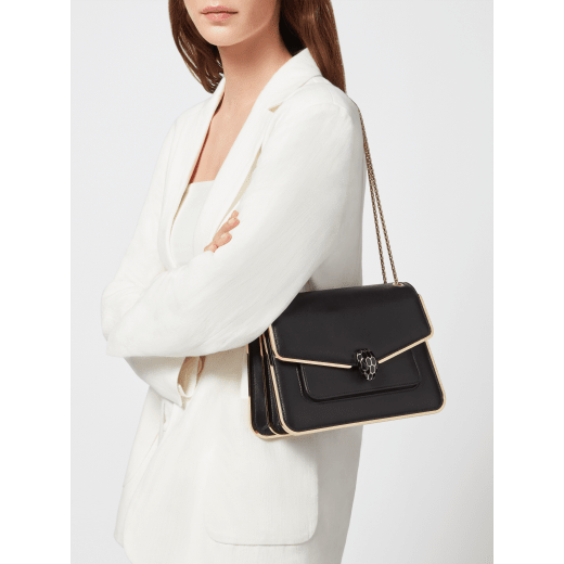 Serpenti Forever medium shoulder bag in black Metropolitan calf leather with light gold-plated brass frames and black nappa leather lining. Captivating snakehead magnetic closure in light gold-plated brass embellished with black enamel scales, and black onyx eyes. 1077-MF image 6