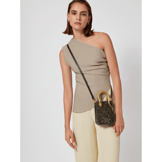 Serpentine mini tote bag in black with black crystals inserts hand-set on suede leather and black nappa leather lining. Captivating snake body-shaped handles in light gold-plated brass embellished with engraved scales and red enamel eyes. 293916 image 1