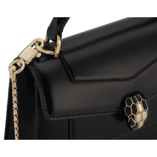 Serpenti Forever mini top handle bag in black calf leather with black nappa leather lining. Captivating snakehead magnetic closure in light gold-plated brass embellished with black enamel and light gold-plated brass scales, and black onyx eyes. SEA-1283-CL image 5