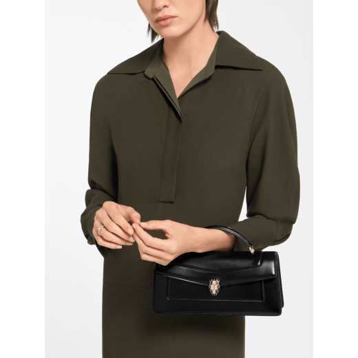 Serpenti Forever Elongated top handle bag in black calf leather with black nappa leather lining. Captivating snakehead magnetic closure in light gold-plated brass embellished with black enamel and light gold-plated brass scales, and black onyx eyes. SEA-001-1390S image 1