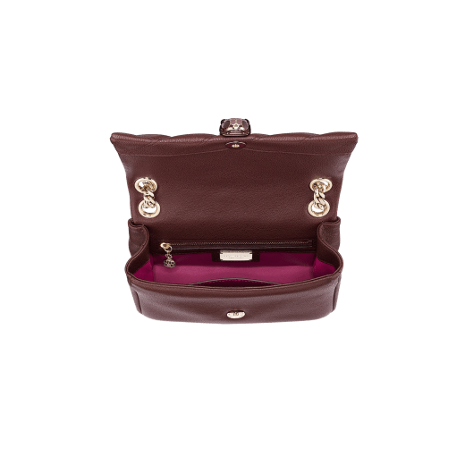 "Serpenti Cabochon" shoulder bag in soft quilted Oxblood bordeaux grainy calf leather, with a graphic motif, and Berry Tourmaline fuchsia nappa leather internal lining. Tempting snakehead closure in light gold plated brass enriched with dégradé Oxblood bordeaux enamel from ultrabright to bright, with black onyx eyes. SC-UCL-DG image 2