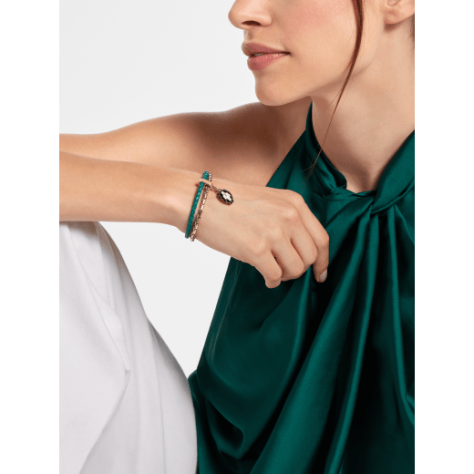 Serpenti Forever bracelet in emerald green braided calf leather and light gold-plated brass chain with magnetic clasp closure. Captivating snakehead charm with black and white agate enamel scales and black enamel eyes. SerpBraidChain-WCL-EG image 2