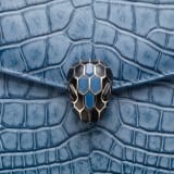 Serpenti Forever shoulder bag in Niagara sapphire blue Cloudy alligator skin with black nappa leather lining. Captivating snakehead closure in light gold-plated brass embellished with black enamel scales, blue jade scales in the centre and black onyx eyes. 1140HE-A image 6