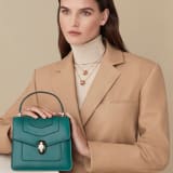 Serpenti Forever small top handle bag in white agate calf leather with heather amethyst fuchsia grosgrain lining. Captivating snakehead closure in light gold-plated brass embellished with black and white agate enamel scales and green malachite eyes. 1122-CLa image 5