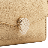 "Serpenti Forever" slim compact wallet in soft emerald green calf leather and black nappa leather. Iconic light gold-plated brass snakehead stud closure, finished with black and white agate enamel, and green malachite eyes. SEA-SLIMCOMPACT-Cla image 4