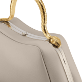 Serpentine small top handle bag in foggy opal grey smooth calf leather with beetroot spinel fuchsia nappa leather lining. Captivating snake body-shaped top handle in gold-plated brass embellished with engraved scales and red enamel eyes, press button closure and light gold-plated brass hardware. SRN-1268b image 5