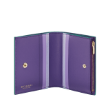 Serpenti Forever compact wallet in jade green Metropolitan calf leather with amethyst purple nappa leather interior and inner nappa leather details in shades of amethyst purple, lavender and sheer amethyst lilac. Captivating snakehead press-stud closure in light gold-plated brass embellished with red enamel eyes. SEA-COMPACTWLT image 2