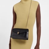 Serpenti Forever medium shoulder bag in black calf leather with black nappa leather lining. Captivating snakehead magnetic closure in light gold-plated brass embellished with beige noisette enamel and light gold-plated brass scales, and black onyx eyes. SEA-001-1344M image 1