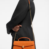 Serpenti Forever Elongated top handle bag in Terracotta nubuck leather with Terracotta nappa leather lining. Captivating snakehead magnetic closure in light gold-plated brass embellished with Terracotta enamel and gold-plated brass scales, and black onyx eyes. 295620 image 1