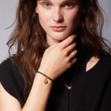 Serpenti Forever bracelet in emerald green braided calf leather. Light gold-plated brass captivating snakehead charm embellished with red enamel eyes, attached on the frontal clasp closure. SERP-HERBRAID-WCL-EG image 1