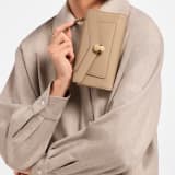 Serpenti Forever phone case in foggy opal calf leather with linen agate nappa leather lining. Captivating snakehead magnetic closure in light gold-plated brass embellished with foggy opal enamel and light gold-plated brass scales, and black onyx eyes. SEA-PHONE-POUCH image 1
