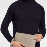 Serpenti Forever pouch in black calf leather with black nappa leather interior. Captivating snakehead rivet in dark ruthenium-plated brass embellished with red enamel eyes. SEA-UNIPOUCH-CL image 1