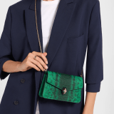 Serpenti Forever chain wallet in vivid emerald shiny karung with black nappa leather interior. Captivating snakehead magnetic closure in light gold-plated brass, embellished with black enamel and light gold-plated brass scales, and malachite eyes. SEA-CHAINPOCHETTEexotic image 1