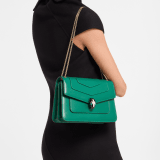 Borsa a spalla media Serpenti Forever in vitello nero con fodera in gros-grain verde smeraldo. Accattivante chiusura Serpenti in ottone placcato oro chiaro con squame in smalto nero e bianco agata e occhi in malachite verde. 1077-CLa image 1